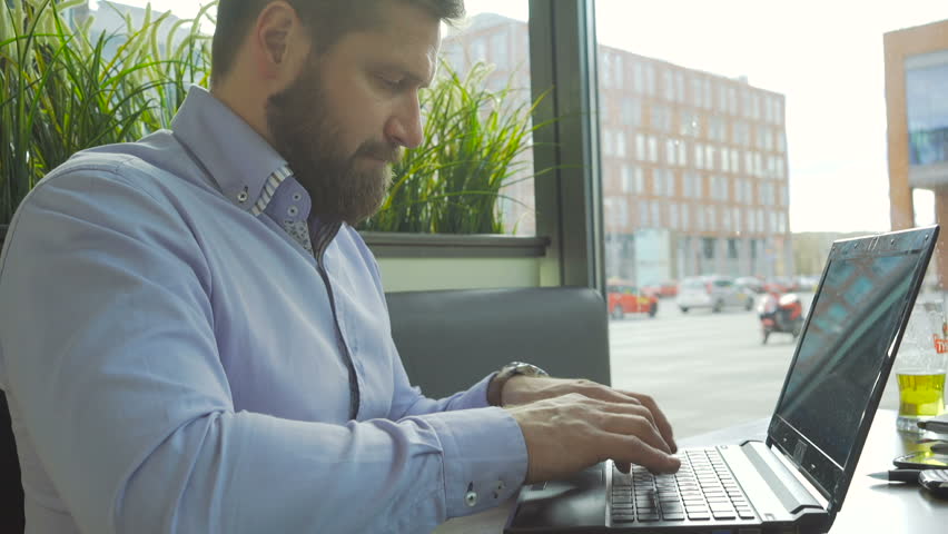Businessman typing on laptop computer, look at camera, profile close steadicam Royalty-Free Stock Footage #25051076