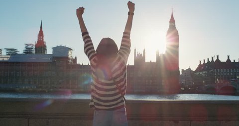 Young tourist woman arms raised enjoying european travel adventure celebrating beautiful city sightseeing exploration