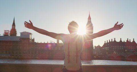 Young tourist man arms raised enjoying european travel adventure celebrating beautiful city sightseeing exploration