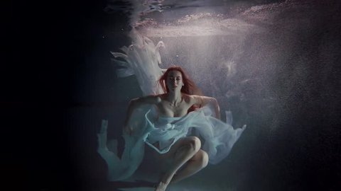 young woman swimming under the water