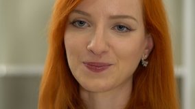 4K Young beautiful redhead businesswoman talking to her colleague or giving an interview for a job position. Close up shot.
