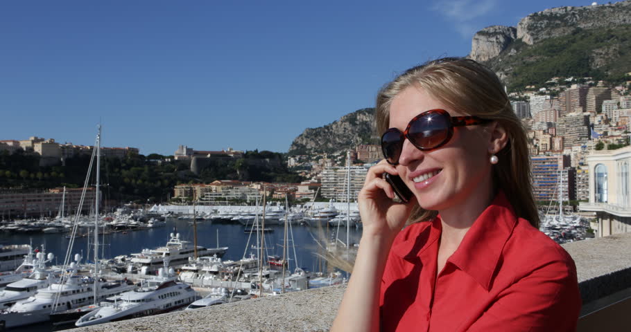 4K Smiling happy girl, blonde woman talk at cell phone mobile in Monte Carlo