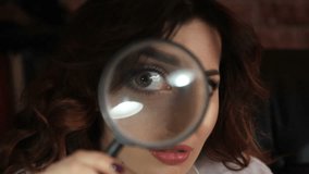 pretty brunette woman puts a magnifying glass to eyes and mouth showing teeth - Powered by Shutterstock - Get 15% off with code: PIKWIZARD15
