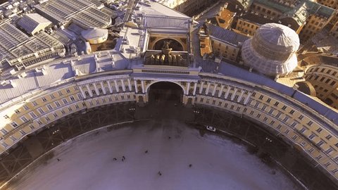 Aerial view of Palace Square and Alexander Column at sunset, a gold dome of St. Isaac's Cathedral, the Winter Palace, the Hermitage, Peter and Paul fortress, triumphal chariot, little people walks