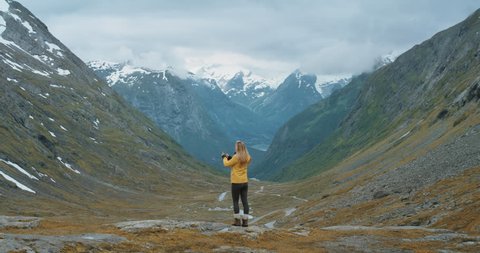 Woman taking photograph snow capped mountains smartphone photographing scenic landscape nature background view enjoying vacation travel adventure Norway Video de stock