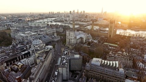 Panoramic Aerial Shot of Houses of Parliament & Big Ben in Central London features The London Eye Wheel, River Thames and Iconic Business Buildings Skycrapers with Beautiful Sunrise 4K