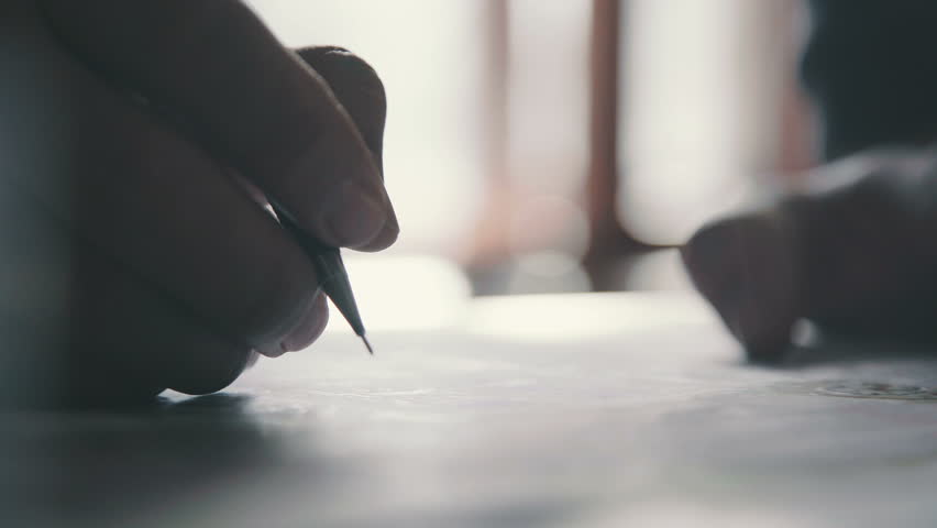 Close-up: the man bends over the desk and makes notes with a pen, leaning on the table. Close-up: a writing pen. The man's hand holds the pen and guides the line along the paper. Royalty-Free Stock Footage #25067789