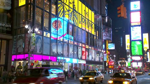 New York, NY - CIRCA 2006: Giant windows, billboards and neon signs surround the gawkers in Times Square at night
