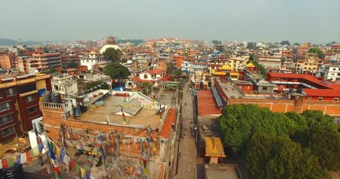 Flying above houses of Kathmandu, Nepal. Aerial view of white Boudhanath stupa
