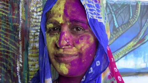 Mumbai / India 13 March 2017 An Indian woman's face is smeared with colored powder during celebrations of the Holi festival. at malad Mumbai Maharashtra India Video Stok
