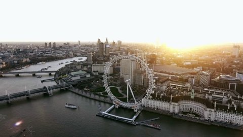 Panoramic Aerial Shot of Houses of Parliament & Big Ben in Central London features The London Eye Wheel, River Thames and Iconic Business Buildings Skyscrapers with Beautiful Sunrise 4K