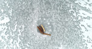 Cinema 4k aerial closeup on marked ice hole or a glade, on a cloudy winter day, in Nuuksio national park, Finland