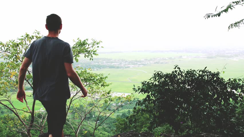 Successful man raising arms after cross track running on summer sunset. Fitness male athlete with arms up celebrating success and goals after sport exercising and working out