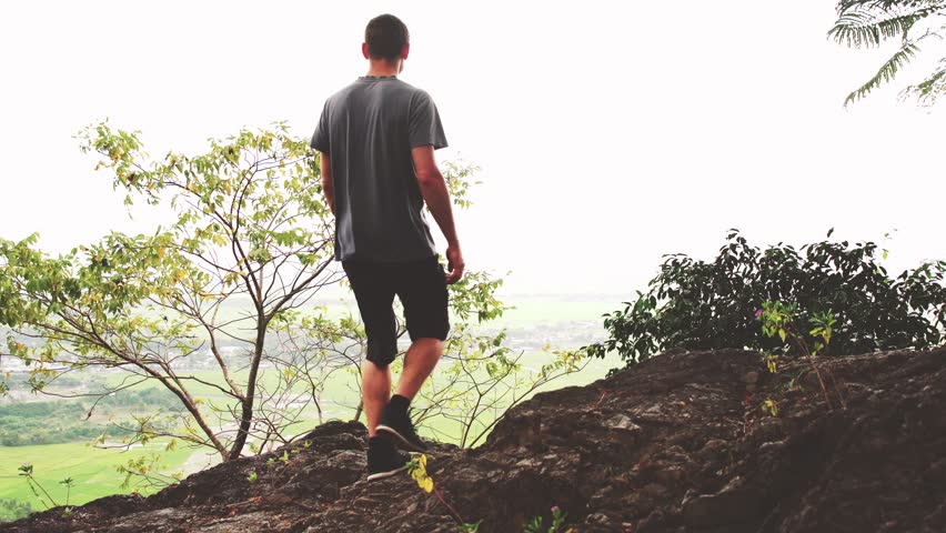 Successful man raising arms after cross track running on summer sunset. Fitness male athlete with arms up celebrating success and goals after sport exercising and working out