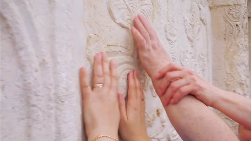 hands touch the walls of the Christian Church