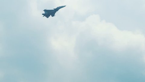 An su-35 Fighter Jet flying high above the clouds. Russian fighter flies a dangerous maneuver. Airshow fighter aircraft. aircraft flying in the air difficult maneuver