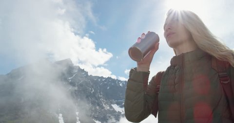 Close up portrait of Woman at top of mountain in nature with blonde hair blowing in wind above the clouds view Hiker Girl in Norway Slow Motion