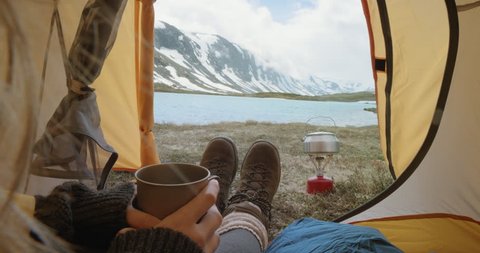 Camping woman lying in tent Close up of Girl feet wearing hiking boots relaxing on vacation POV