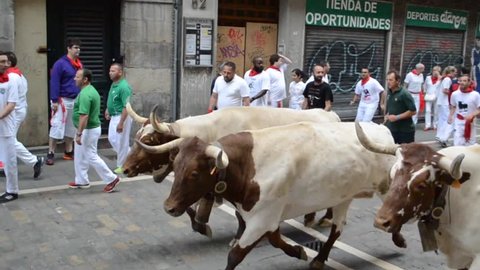 PAMPLONA, SPAIN - JULY 2016. People in the Running of the Bulls during San Fermin Festival in famous Estafeta St of Pamplona, July 2016