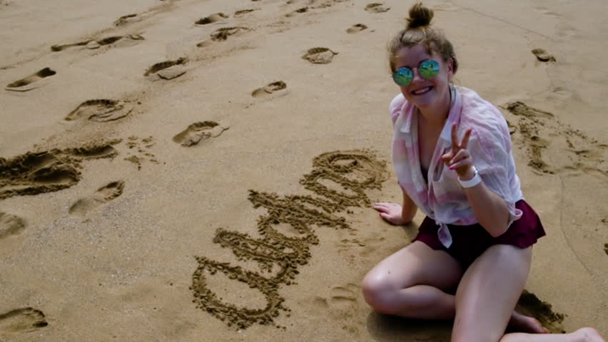 teen girl finishes writing "aloha" sand Stok Videosu (%100 Telifs...
