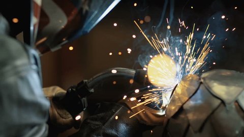 Slow motion welding with sparks close up side angle