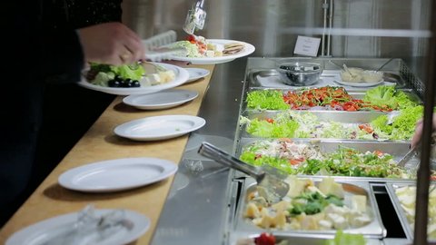 People impose food. Catering. Impose Salad. Food Distribution Table.