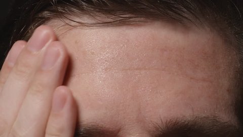 Man wipes his sweating forehead - Close up