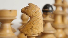 Close-up of white player knight positioned on chequered fields slow tilt 4K 2160p 30fps UltraHD footage - Wooden chess set figures arranged on playing table 3840X2160 UHD video