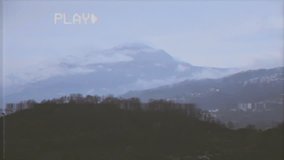 Fake VHS tape: a mountain view on a slow morning. Snow-capped peaks and green bushes.
 - Powered by Shutterstock - Get 15% off with code: PIKWIZARD15