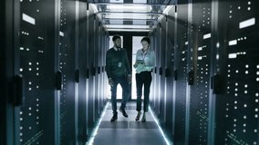 In Data Center/ Server Room IT Engineer Consults with Female Chief Engineer who Holds Tablet Computer. Shot on RED EPIC-W 8K Helium Cinema Camera. - Powered by Shutterstock - Get 15% off with code: PIKWIZARD15