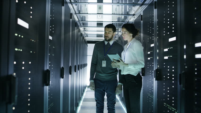 Male and Female Server Technicians Working in Data Center. Running Rack Server Diagnostics. Woman Uses Tablet Computer. Shot on RED EPIC-W 8K Helium Cinema Camera. Royalty-Free Stock Footage #25116998