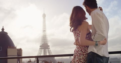 Romantic couple in Paris Eiffel Tower embrace kissing honeymoon enjoying European summer holiday travel vacation adventure