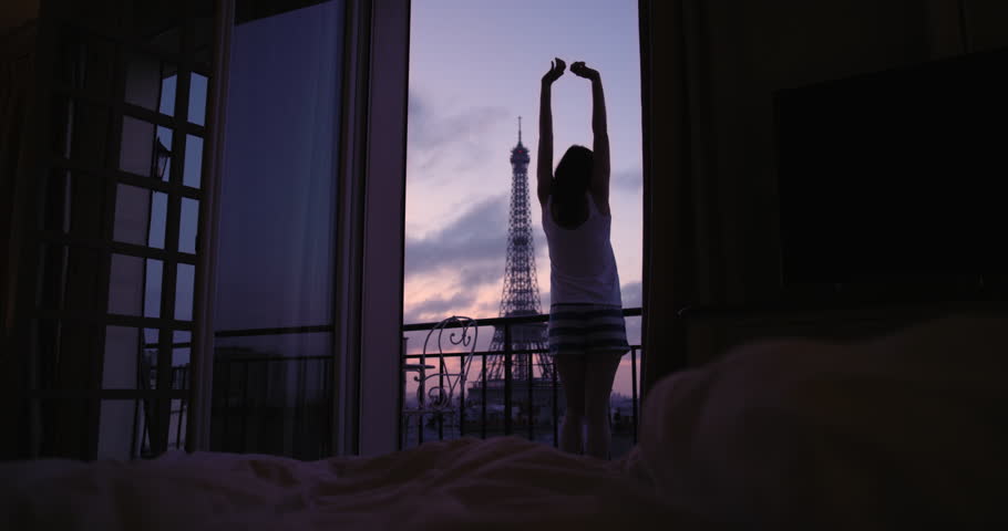 Young tourist woman stretching at sunrise on hotel terrace with view of Eiffel Tower Paris arms raised enjoying european travel adventure celebrating beautiful city Royalty-Free Stock Footage #25126154