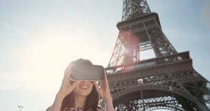 Young tourist woman at Eiffel tower Paris wearing virtual reality headset watching 360 video imagination VR concept
