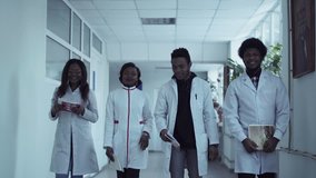 Four medical students walking down hospital corridor