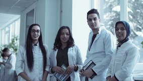 Diverse group of four young medical students stood together