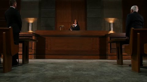 Lawyers stand for a female judge in court room