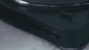 CU female hand turning on modern vinyl turntable player. 4K UHD RAW edited footage