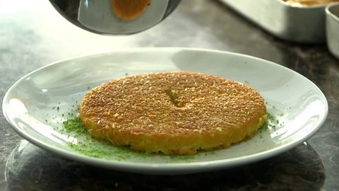 Delicious traditional Turkish kunefe with pistachio on it. Served hot and with syrup. Cooking Kunefe.