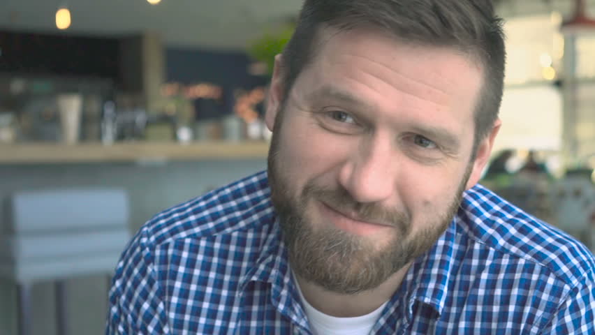 Happy man talking and lauging, portrait, cafe, very close steadycam shot