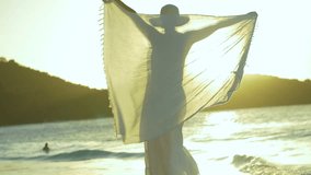 slow motion video of woman twirling sarong on tropical beach at sunset 