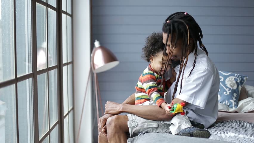 mixed race boy sitting on father's Stock Footage Video (100% Royalty ...