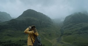 Adventurous Young traveler woman wearing virtual reality headset watching 360 video imagination concept Glen Coe Scotland