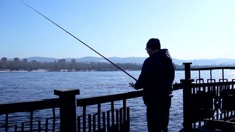 Fisherman fishing with spinning, silhouette
