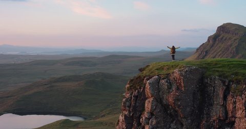 Woman with arms raised on top of mountain looking at Sunrise view Hiker Girl celebrating scenic landscape enjoying nature vacation travel adventure Quiraing Walk on the Isle of Skye in Scotland