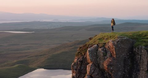 Woman with arms raised on top of mountain looking at Sunrise view Hiker Girl celebrating scenic landscape enjoying nature vacation travel adventure Quiraing Walk on the Isle of Skye in Scotland