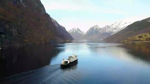 OSLO, Norway - March 2017. The Fanaraaken ferry from Flam to Gudvangen on the Norway in a Nutshell tour. Sailing in the fjord Aurlandsfjorden, part of the Sognefjorden fjord. 4K aerial drone footage.