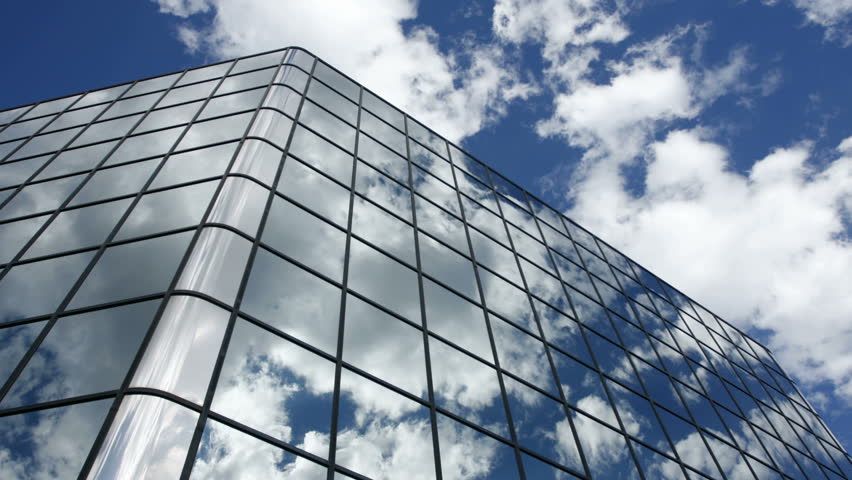 Timelapse of clouds reflected in the many mirrored facets of a modern office