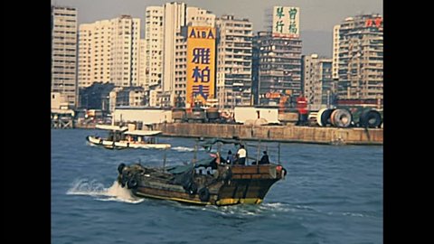 HONG KONG, CHINA - CIRCA 1980: Historic Chinese cargo ship and fishing Sampan boats in Hong Kong port Victoria Harbour. Historic restored archival footage on 1980s.