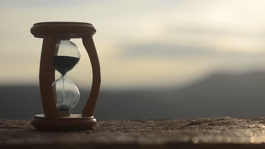 Time concept. Silhouette of Hourglass clock and smoke on blurred nature background at sunset time, or symbols of time under smoke, time ends or love ends. Optimistic or pessimistic ideas.  | Shutterstock HD Video #25181690